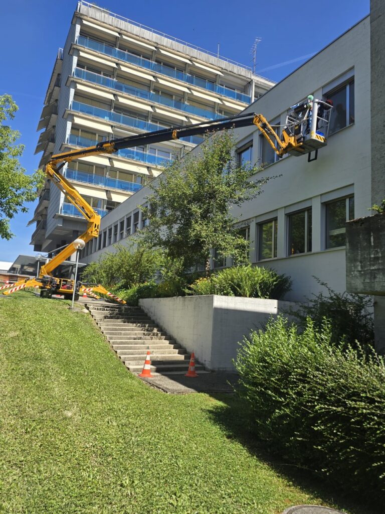 Fensterreinigung an Gebäudefassade mit Gelenkteleskop-Hebebühne in Zürich