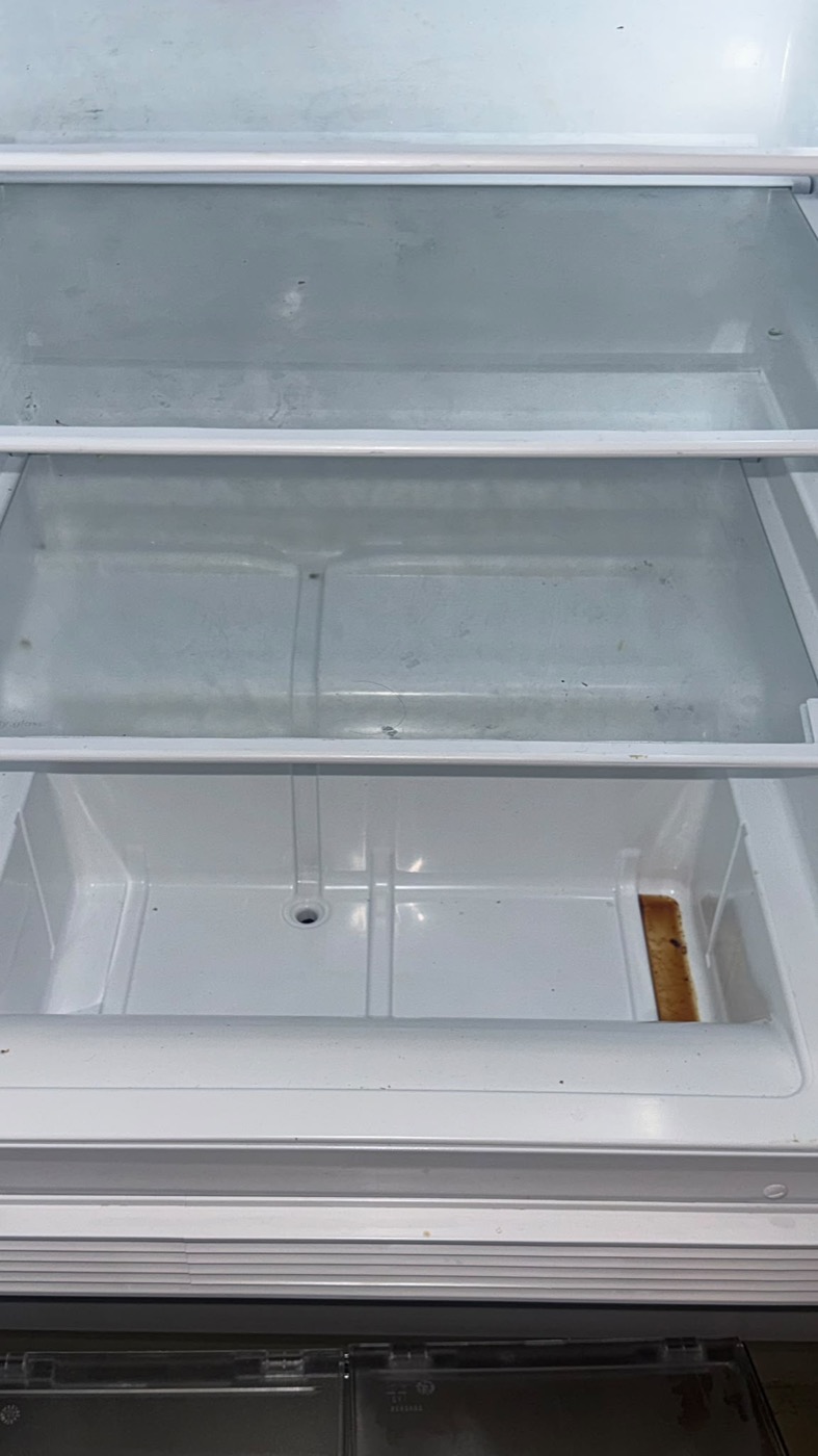 Kühlschrank vor der Reinigung mit Verschmutzungen in Fächern und Gemüseschublade
